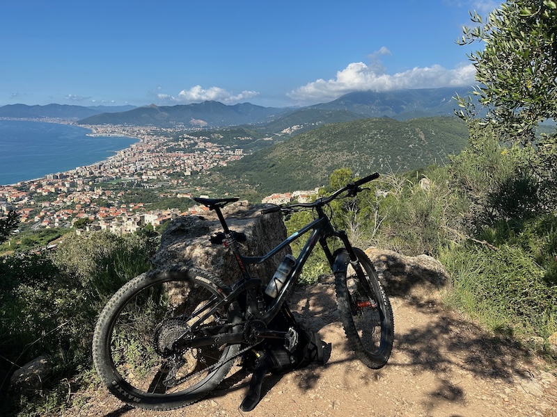 A mountain bike leaning against a rock with the sea in the background