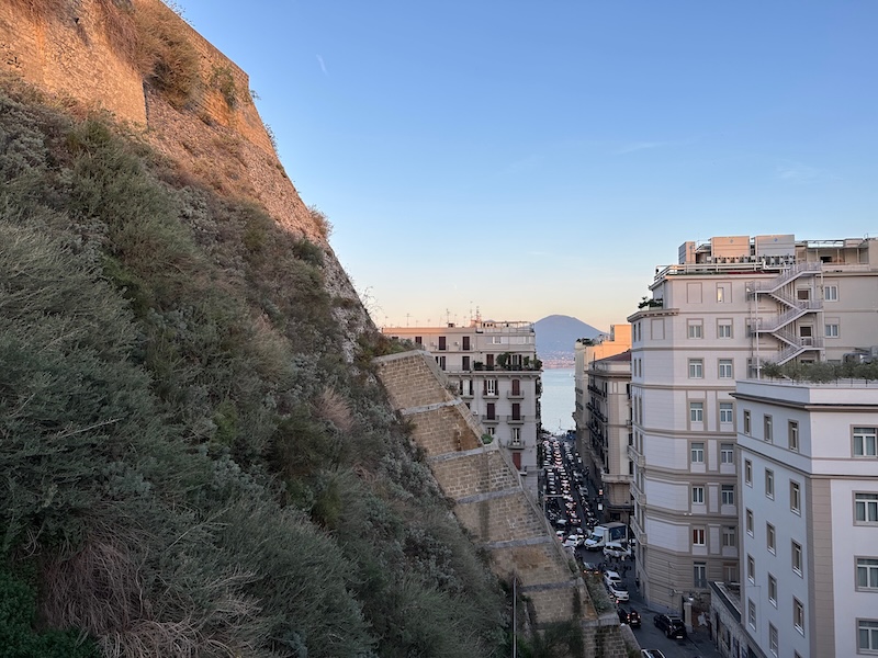 Mount Vesuvius seen between buildings from a rooftop terrace