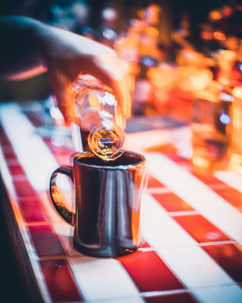 A mug on a table with a bottle