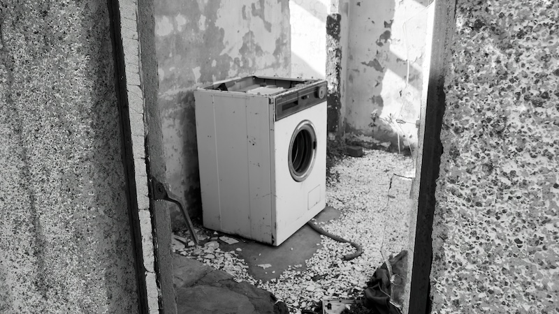An abandoned washing machine in an alley